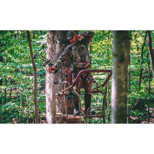 Hunter using Trophy Tree stands Mountaineer ladder stand in forest hunting environment