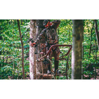 Hunter using Trophy Tree stands Mountaineer ladder stand in forest hunting environment